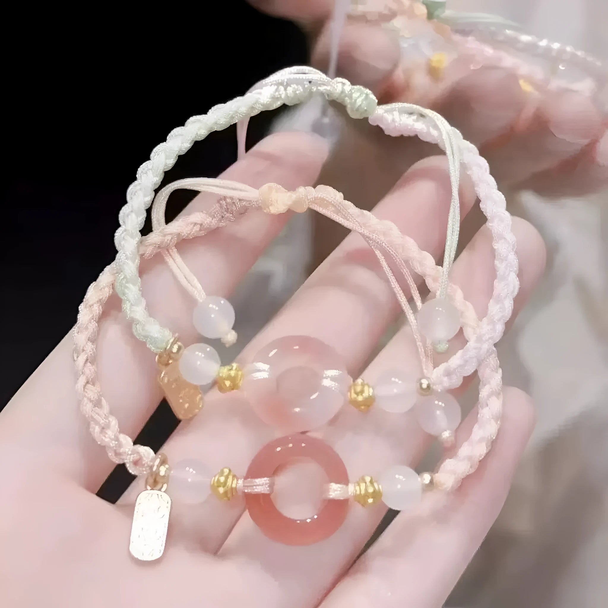 DIY woven unisex bracelet with peach blossom and peace buckle design in black, green, or pink.