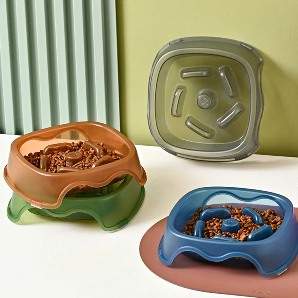 A blue plastic slow-feeder dog bowl on a wooden floor.