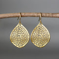 Gold alloy retro leaf hollow drop earrings on neutral background