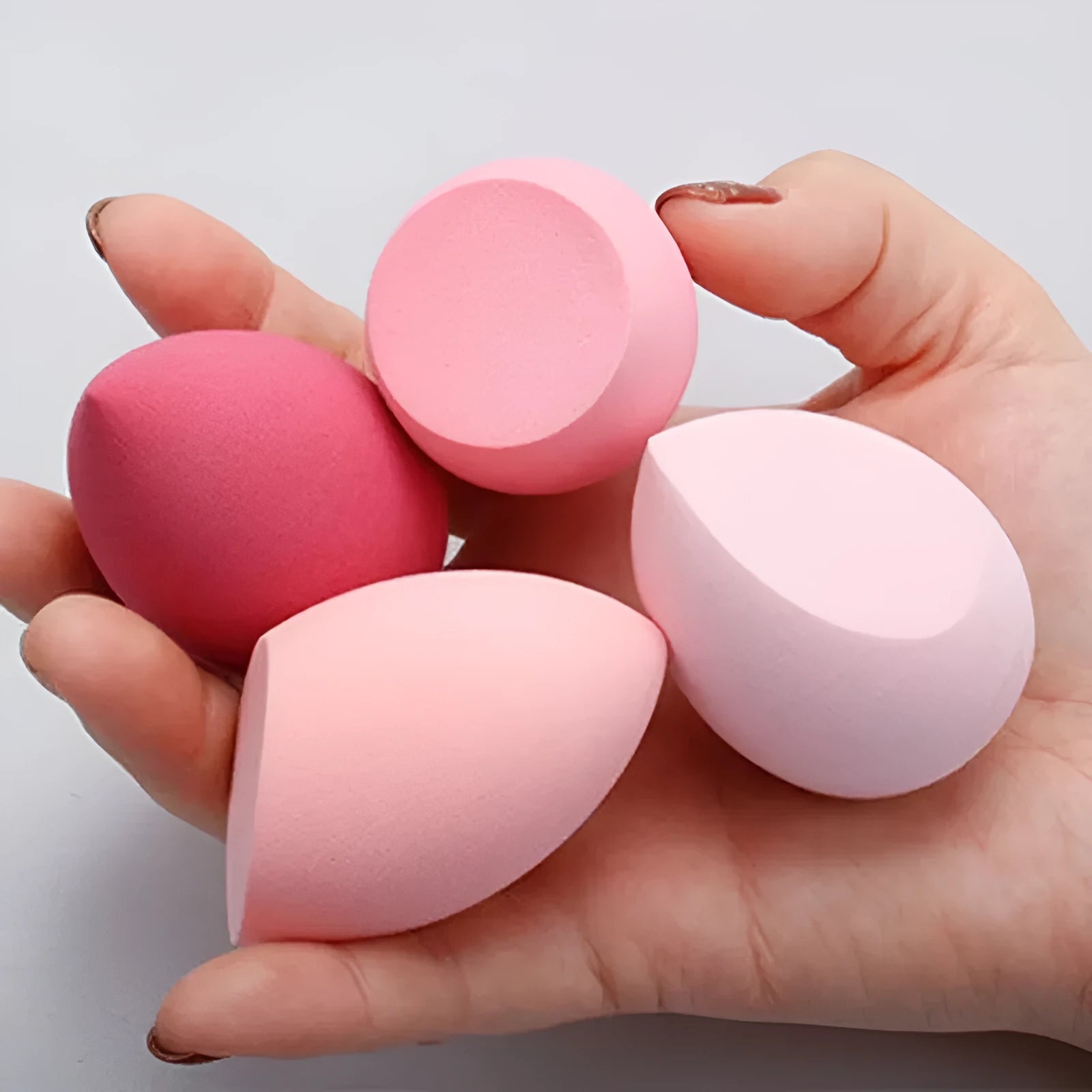 Set of 10 nude, pink and rose red hydrophilic non-latex makeup sponges in bevel drop and peach heart shapes.
