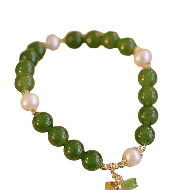 Close-up of a green chalcedony bracelet with round geometric beads on a wrist.