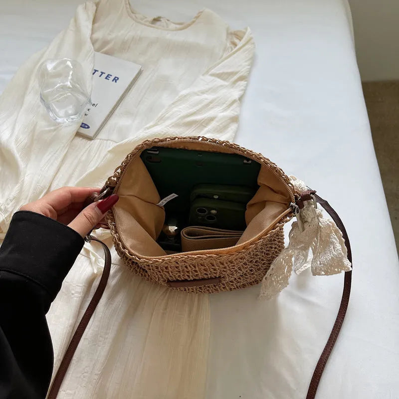 Women's khaki woven straw messenger bag with hollowed pattern and single shoulder strap.