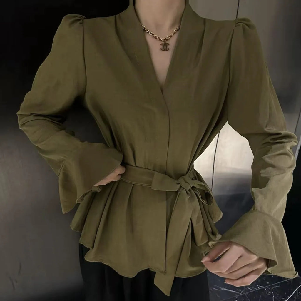 Women's black French-style shirt with an irregular collar and long bell sleeves, showing the tied front detail.