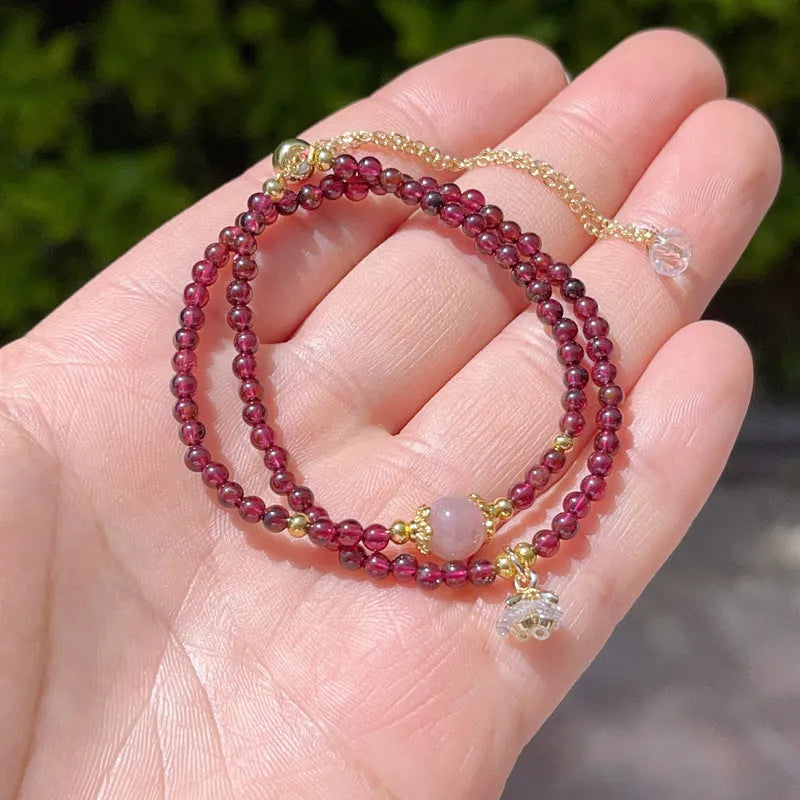 Close-up of a handmade women's natural garnet double ring bracelet in garnet colour.