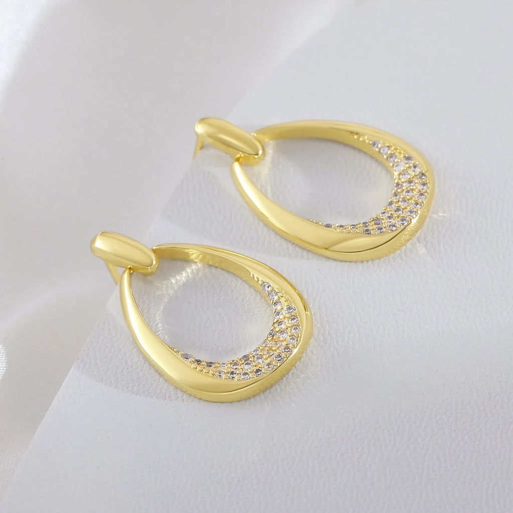 Yellow gold geometric drop earrings for women with simple zircon details on a copper base.