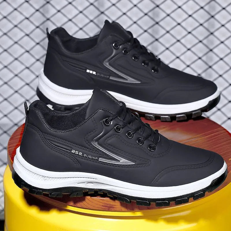 Black and grey low-top waterproof casual shoes with a lace-up front and plastic sole.