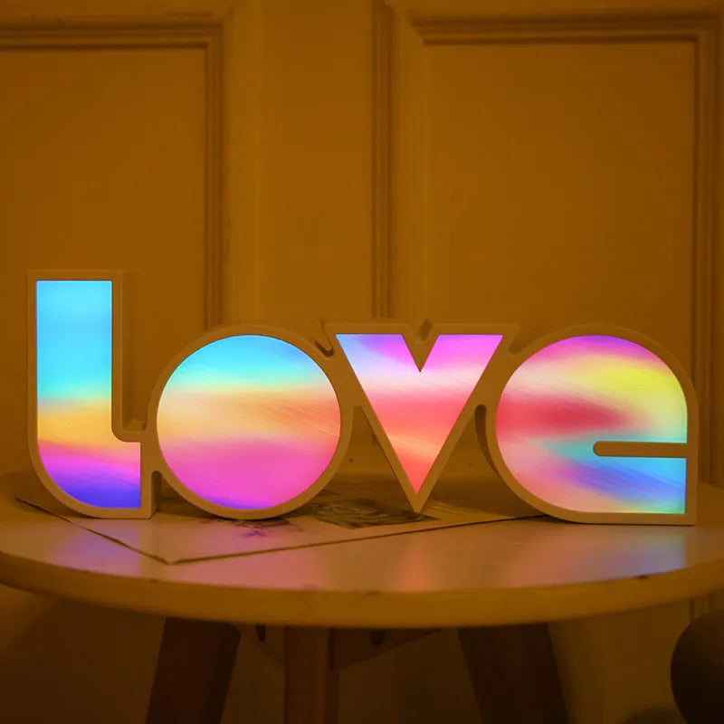 Rainbow style LED Love light for Valentines Day and wedding decoration on a table.