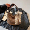 Women's khaki woven straw messenger bag with hollowed pattern and single shoulder strap.