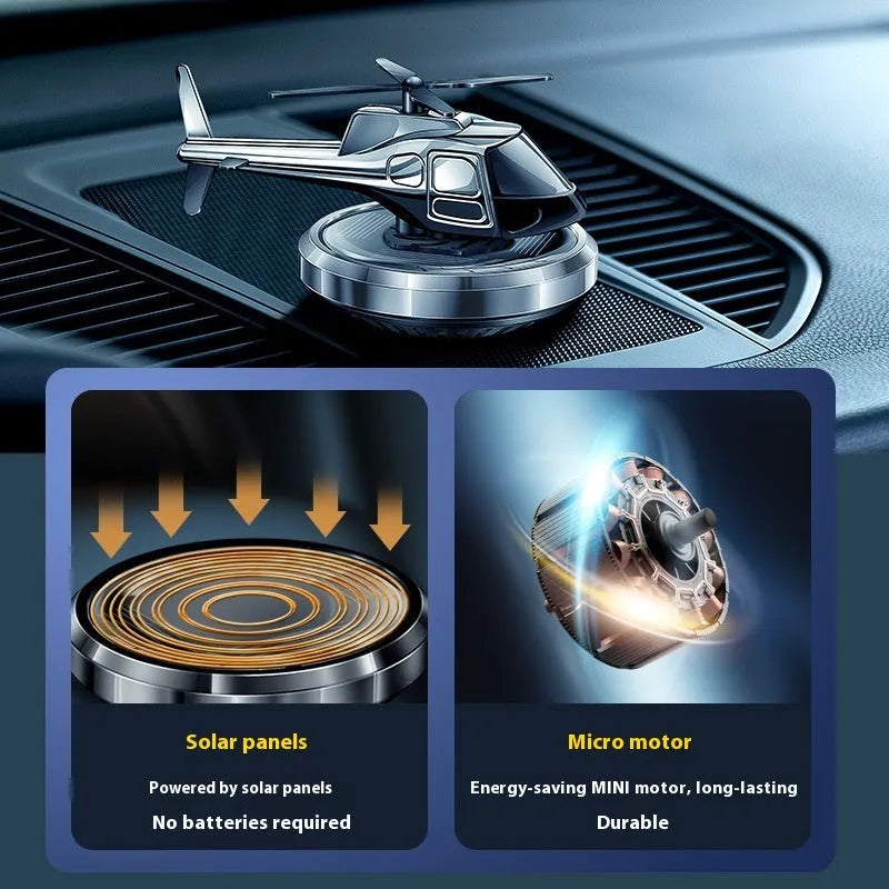 Silver metal solar helicopter car perfume ornament spinning on a car dashboard