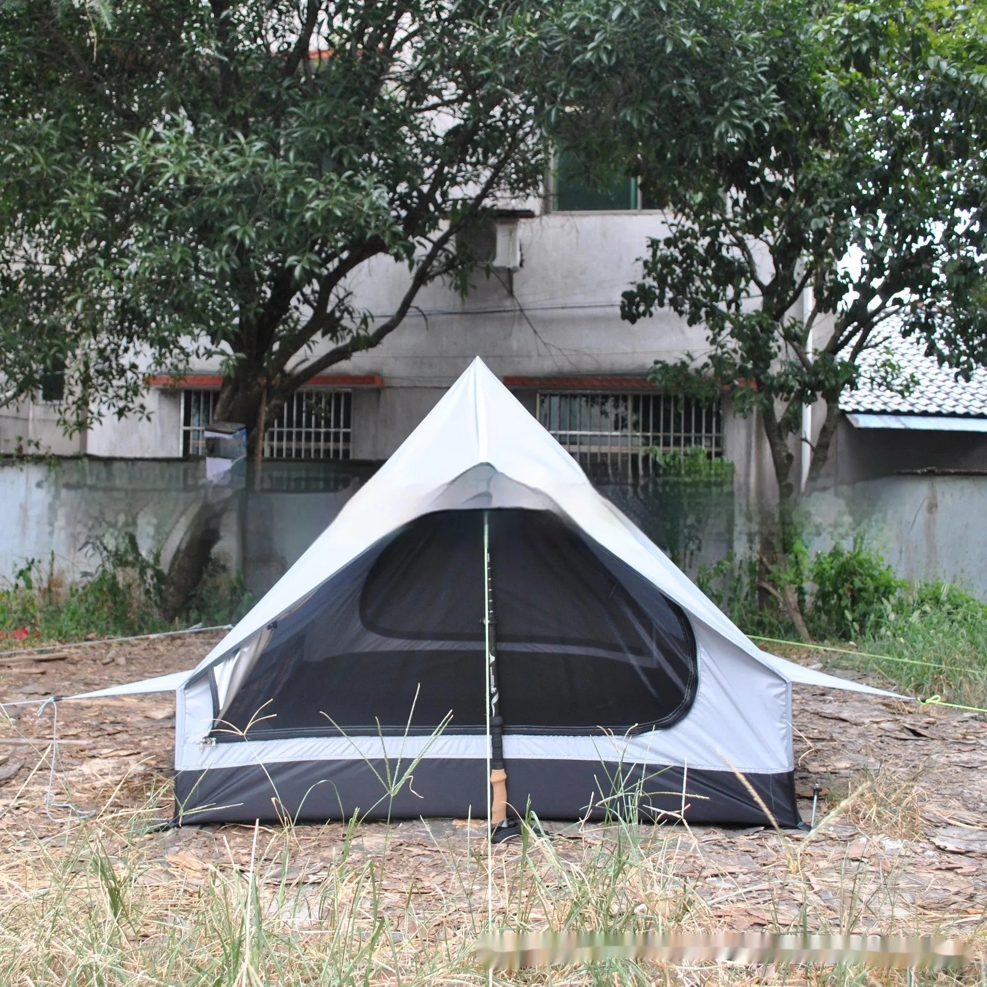 Brown A-line pole-free tent erected with hiking canes showing 2-3 person capacity and waterproof fabric construction