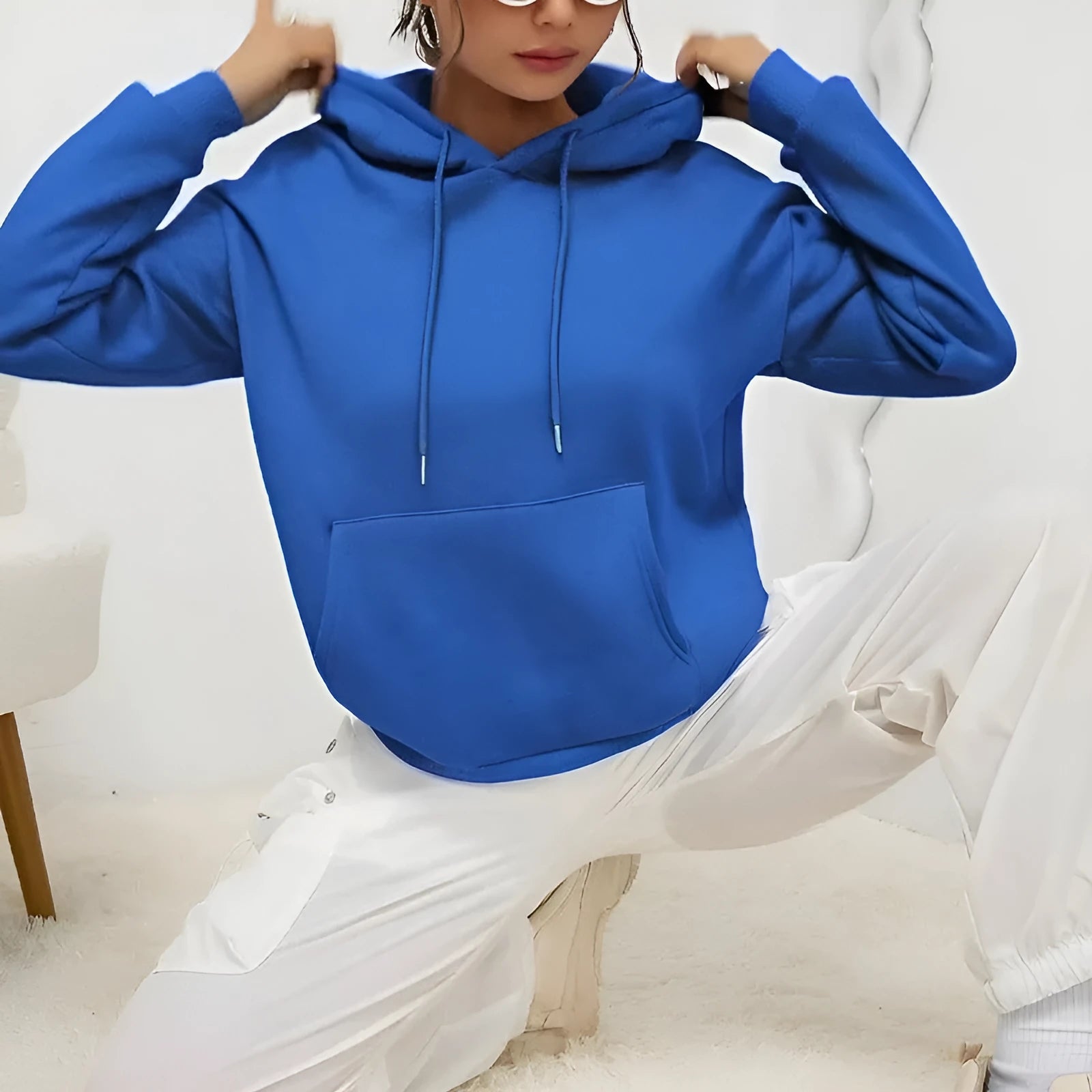 Women's loose fit grey hooded sweatshirt with front pocket and long sleeves on a hanger.