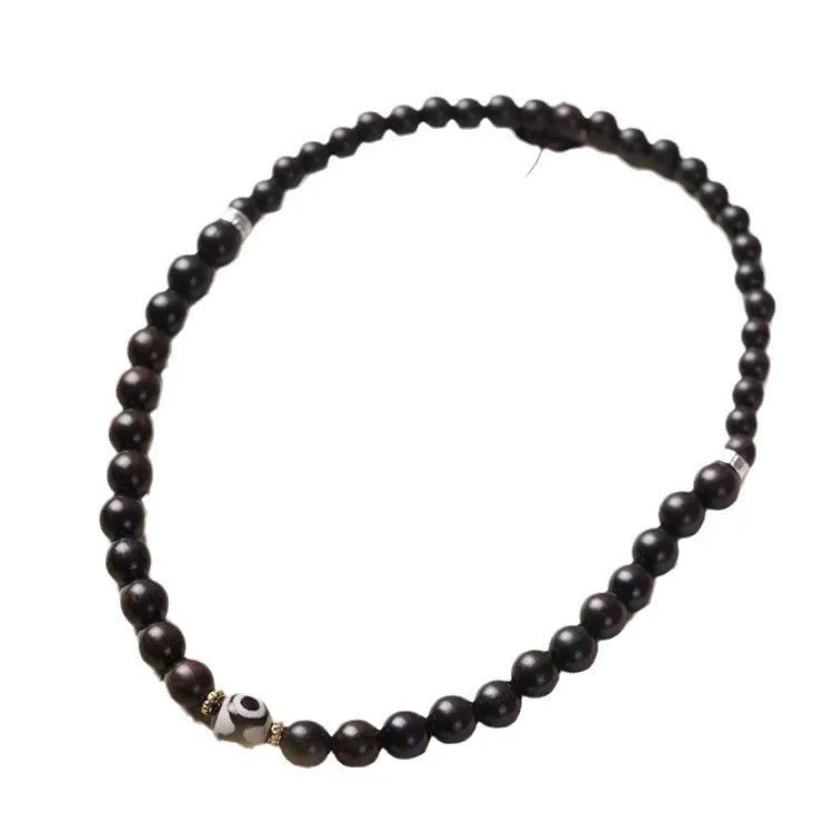 Dark ebony wood bracelet with 8mm Tibet-style beads and circle elements on wrist