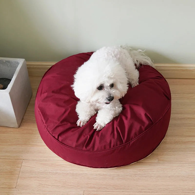 Fluffy pet bed in beige with raised rim on a light wood floor, available in sizes 60 to 80 cm diameter