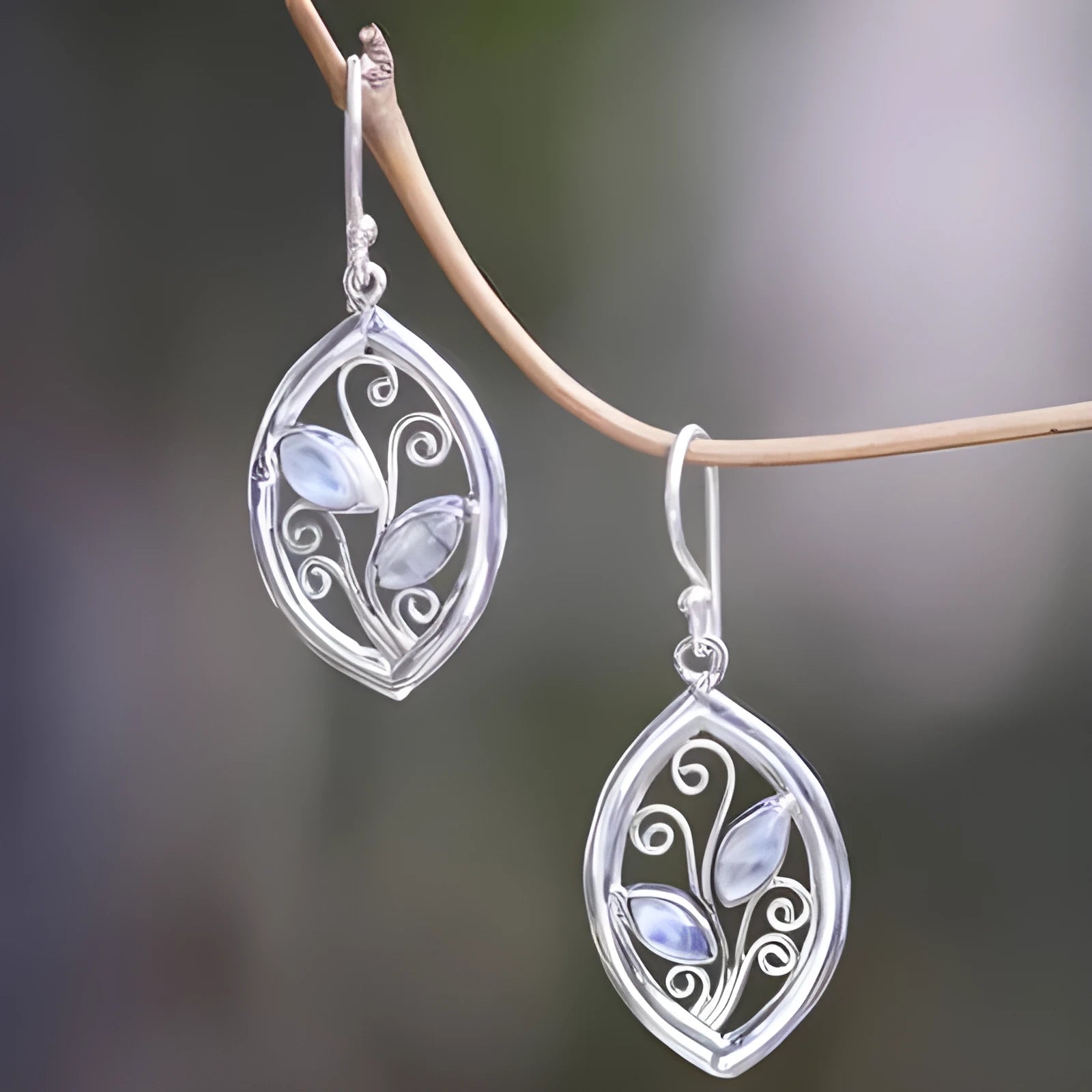 Silver alloy leaf-shaped earrings with an embedded colourful moonstone centrepiece.