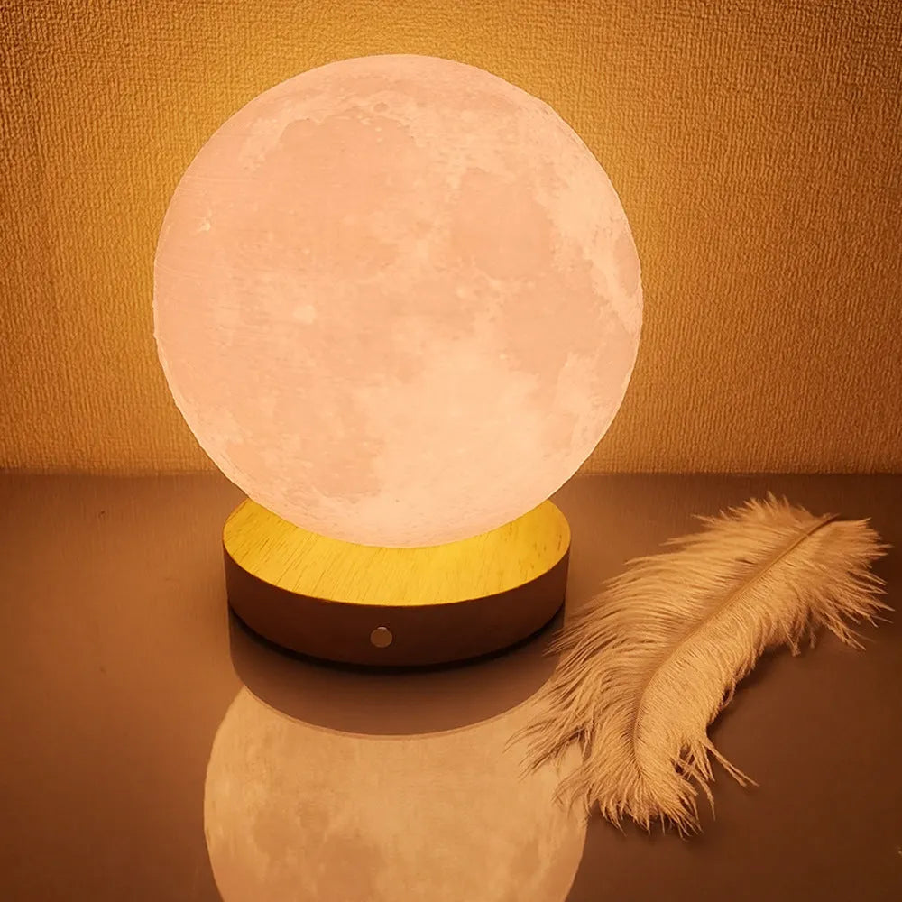 Rotating moon night lamp with wooden base on a table, showing three colour settings and remote control.