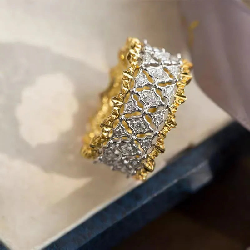 Geometric two-tone copper ring with a round central zircon stone, shown on a finger.