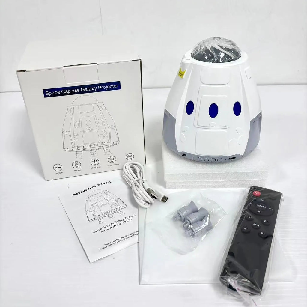 Space capsule shaped USB galaxy projection lamp with remote control on a surface.
