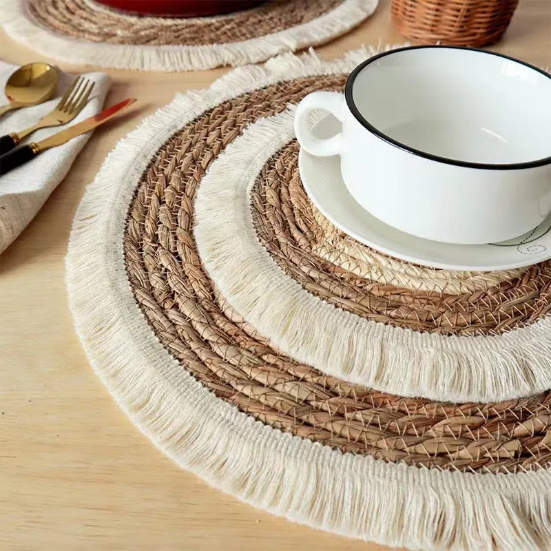 Round Japanese straw placemat with tassel edge in natural papyrus material on wooden dining table