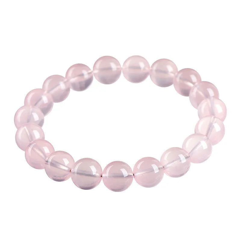 Natural starlight crystal round beads women's bracelet in pink on a wrist, showing polished single circle beads.