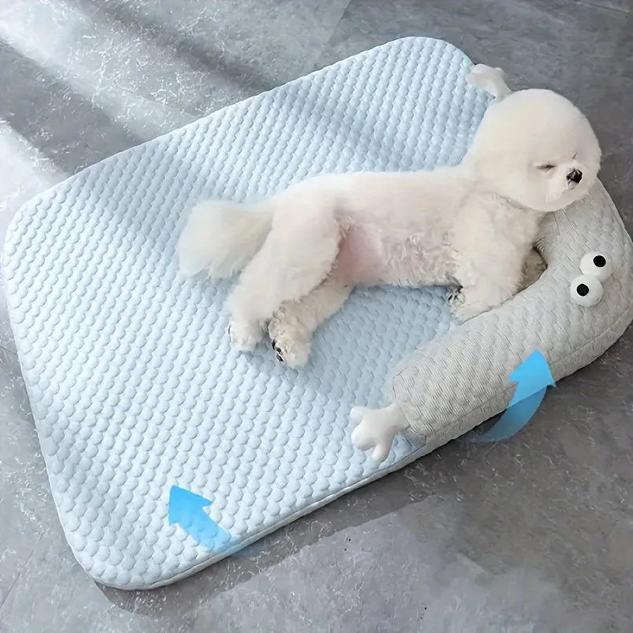 Blue pet cooling pad with big-eyed monster design, shown on a wooden floor.