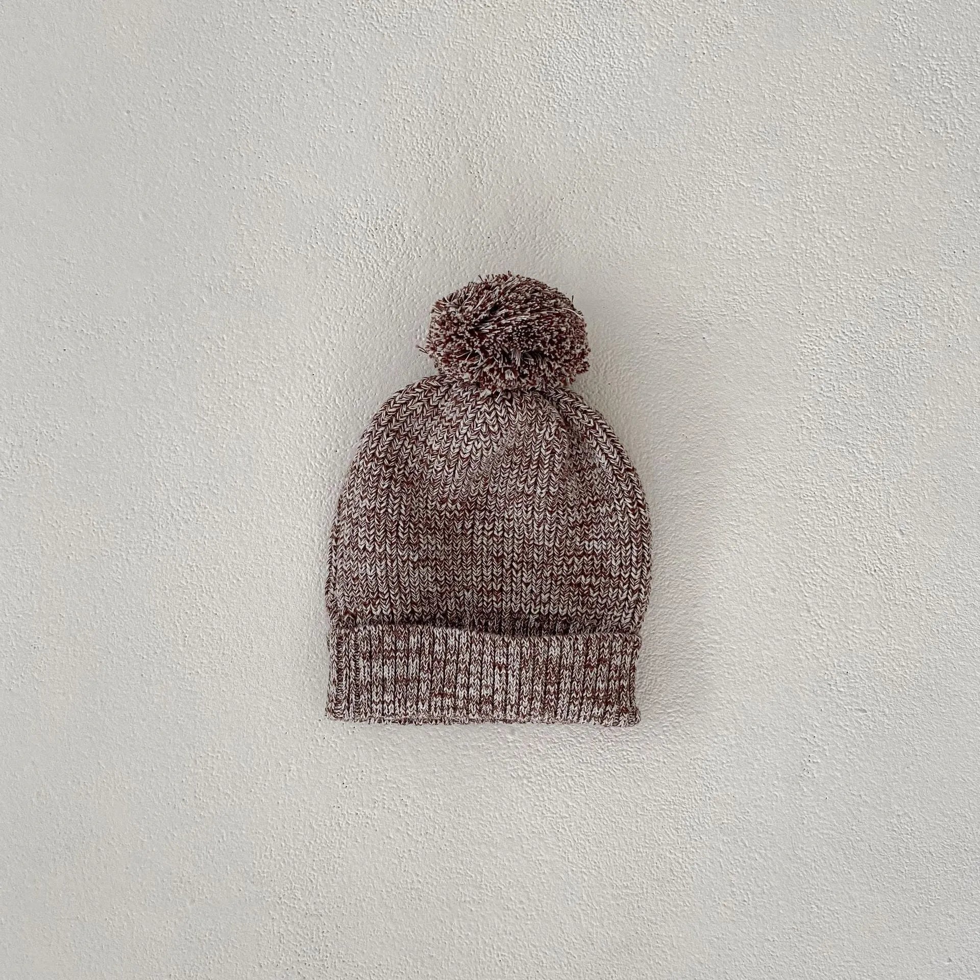 Dark brown knitted baby girl three-piece set with removable fur ball hat, blouse, and shorts
