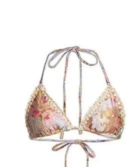 Women's creamy-white floral bikini swimsuit set with matching skirt on beach