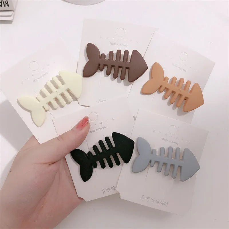 A minimalist fishbone design duckbill clip hair barrette in a muted candy colour.