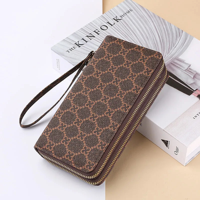 Black retro print long wallet clutch bag with zipper, holding a mobile phone and cards.