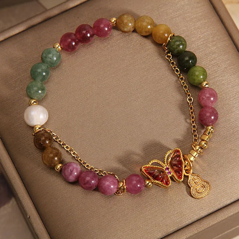 Close-up of a women's agate bracelet with a tourmaline butterfly gourd pendant in natural jade colour.