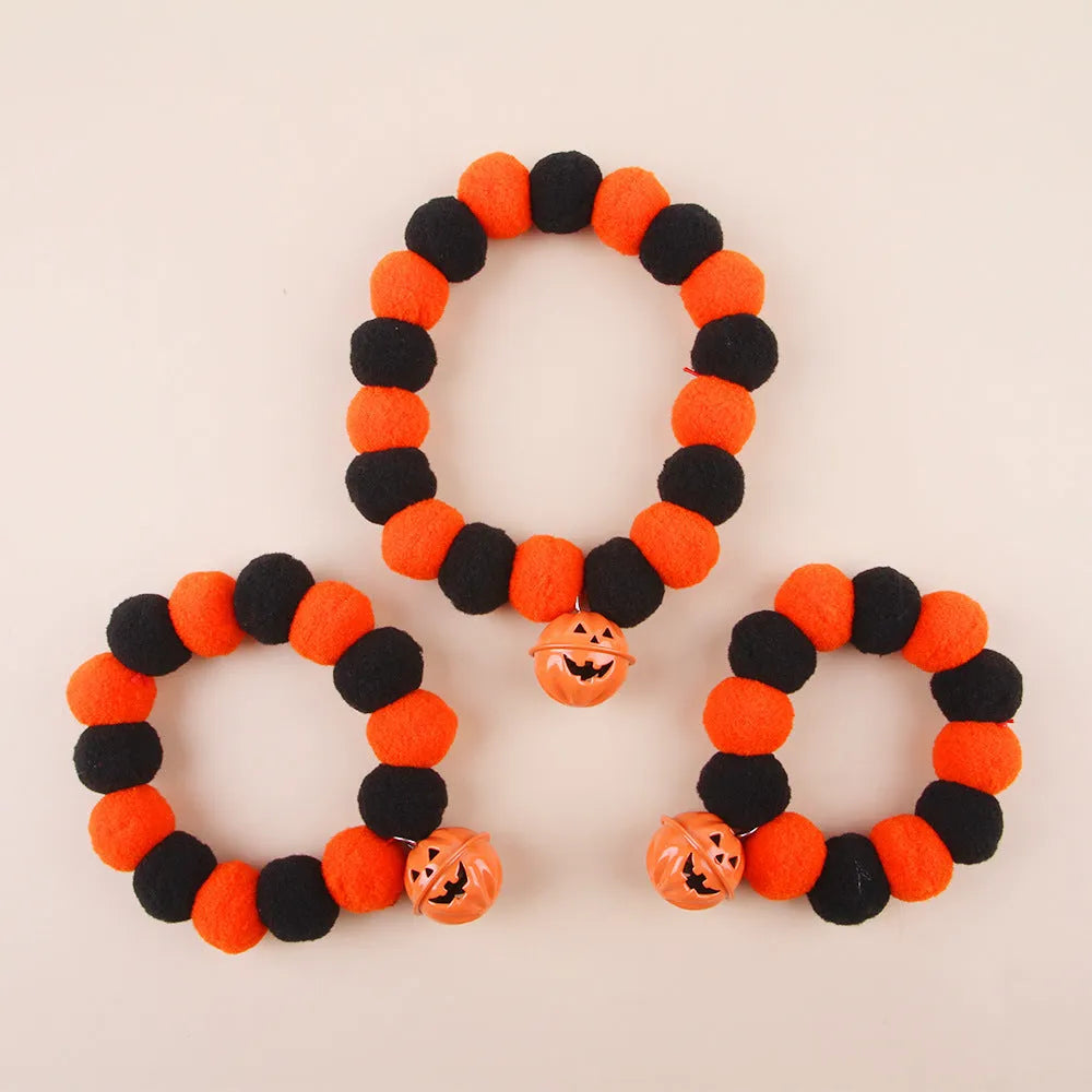 Orange cat collar with a black Halloween pumpkin print and 'trick or treat' text, shown with a buckle.