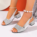 Gold open toe fish mouth sandals with an adjustable buckle on a wooden floor.