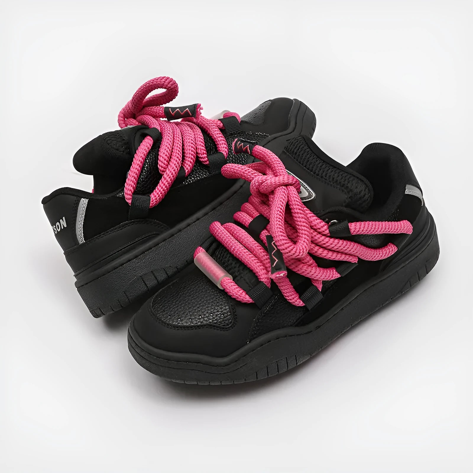 Pair of thick-soled casual lace-up trainers in a solid colour on a white background.