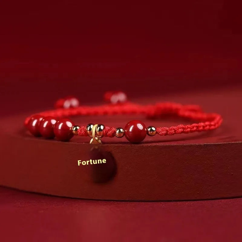 Cinnabar bracelet with braided rope in three colour options featuring round bead or flower blessing card charms