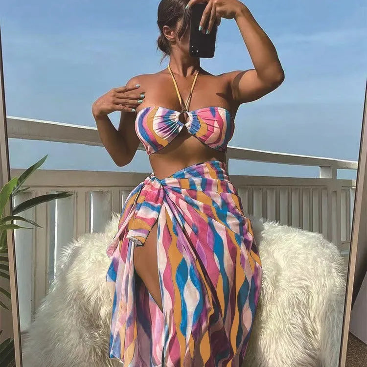 Women's yellow green printed three-piece bikini set with a matching skirt laid flat.
