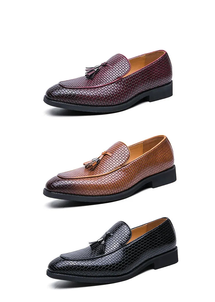 Men's black slip-on leather loafers with a pointed toe and tassel detail on a white background.