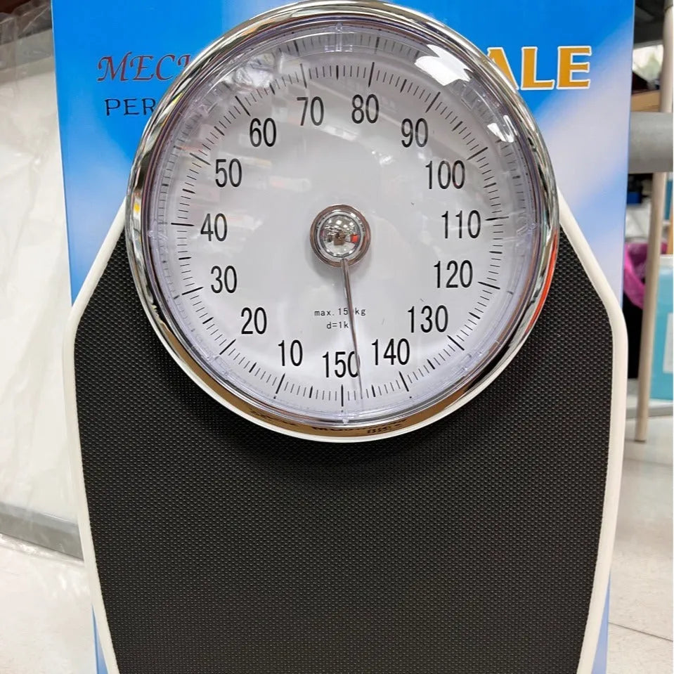 Black mechanical bathroom scale with analogue dial showing weight measurements