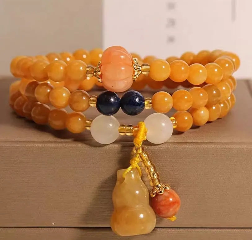 Women's multi-circle bracelet with three strands of natural Jinsi Jade beads and a resin flower calabash pendant on a white background