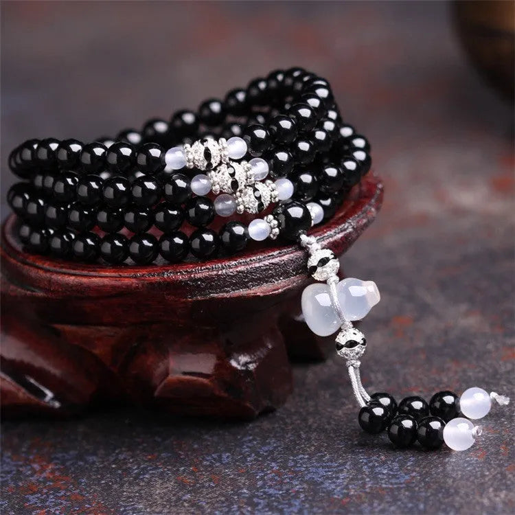 Black agate beaded bracelet with 108 geometric beads and number elements on wrist