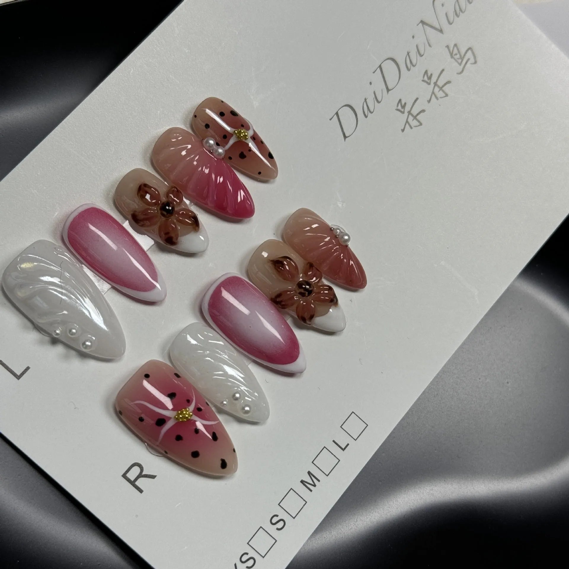 Close-up of hand-painted 3D carved nail art patches with colourful embossed candy patterns.