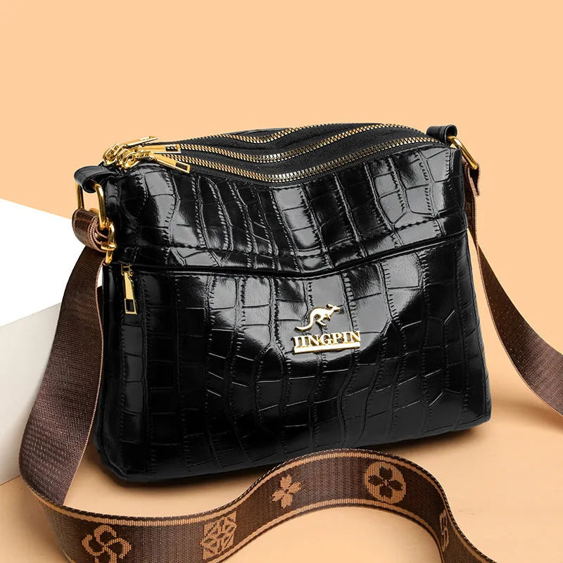 Brown cross body bag with multiple compartments and horizontal suitcase shape