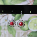 Handmade Miao silver retro earrings with turquoise flower disk and ethnic patterns in black.