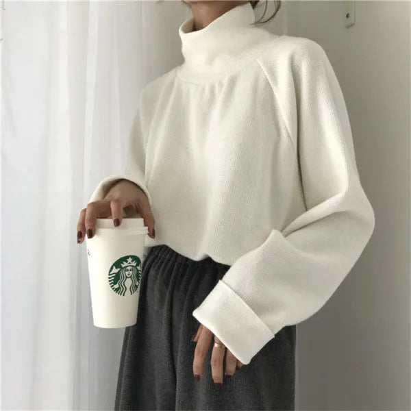 Women's solid colour loose-fit long sleeve top with a half-high collar in white, apricot, or black.