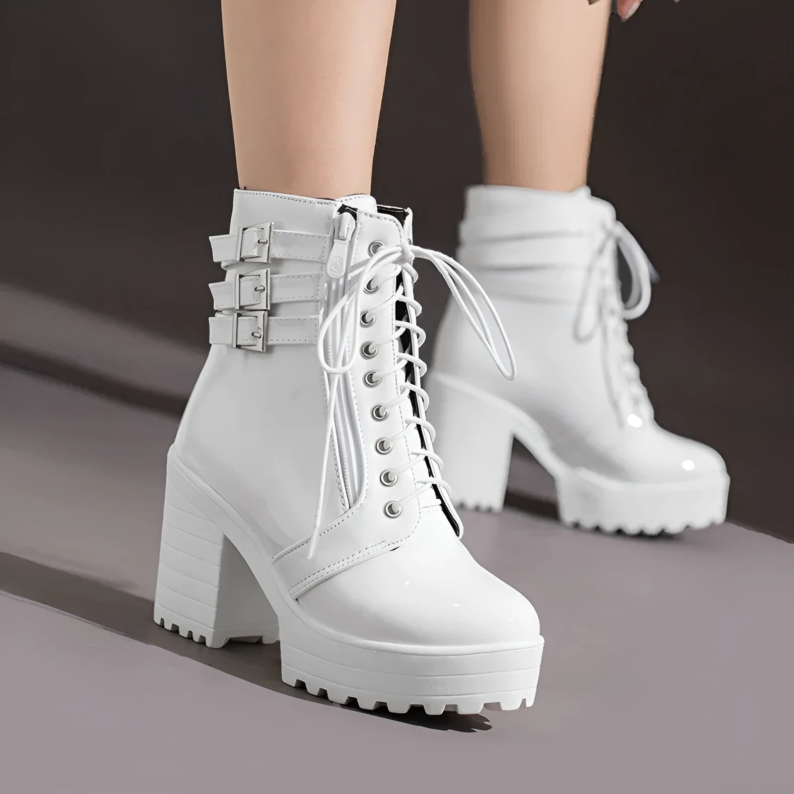 Women's black thick-heel ankle boots with lace-up front and round toe on a rubber sole.
