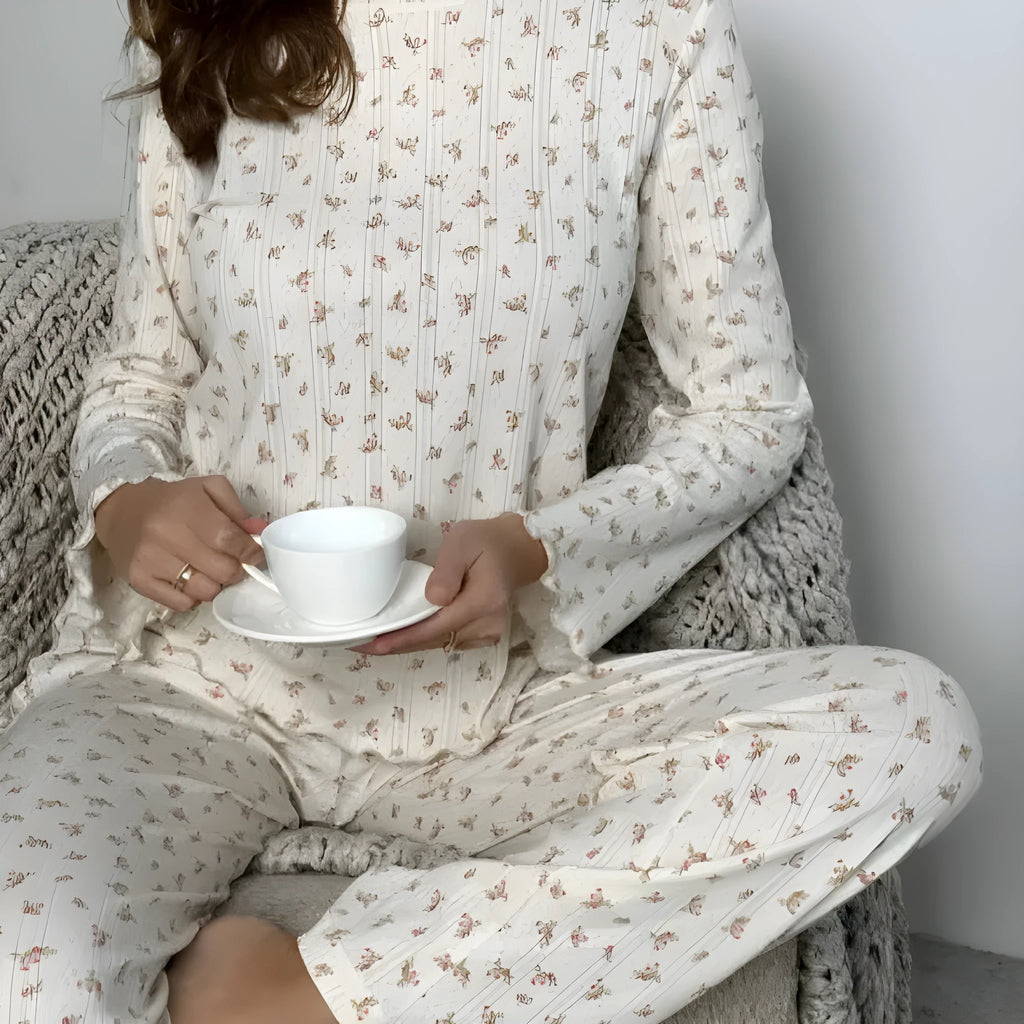 White floral print women's suit with bell sleeve top and wide-leg trousers laid flat