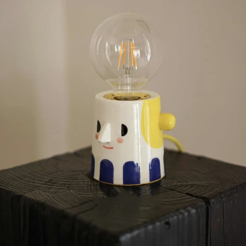 Handmade ceramic table lamp with a spherical white ball headlight shade on a solid base.