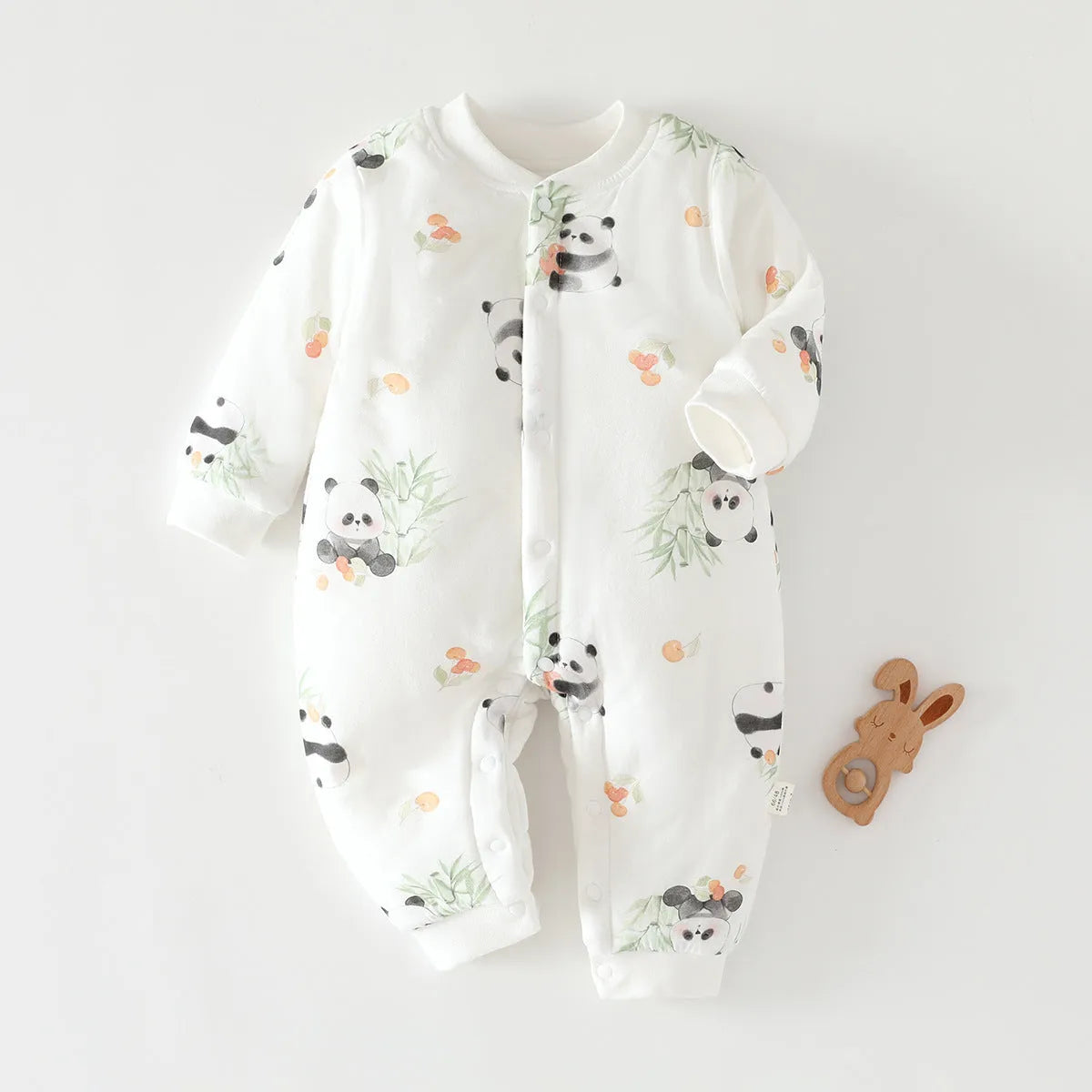 Infant one-piece romper in cotton with closed crotch, long sleeves, and animal-themed colours.