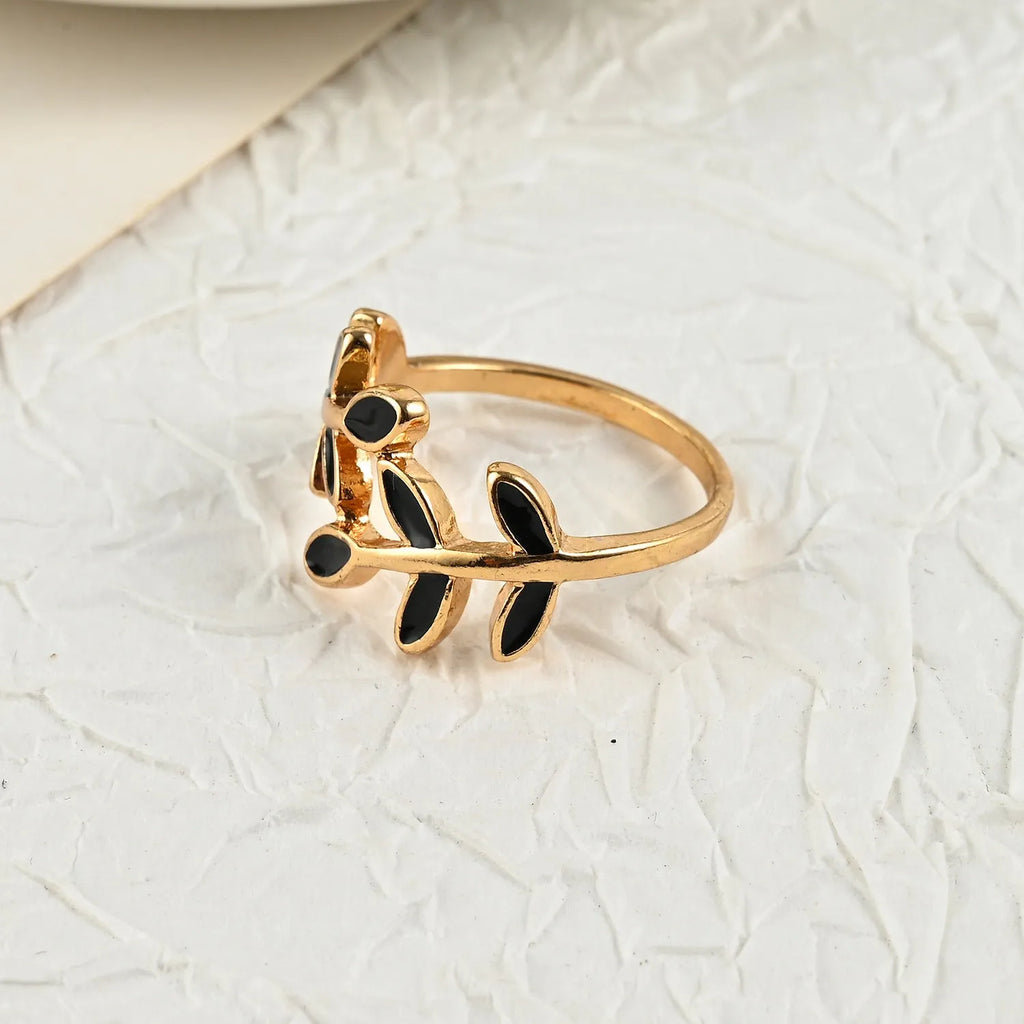 Gold geometric leaf and flower shape acrylic ring for women on index finger.