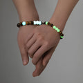 A pair of amber-coloured geometric resin bracelets with a luminous glow, shown together.