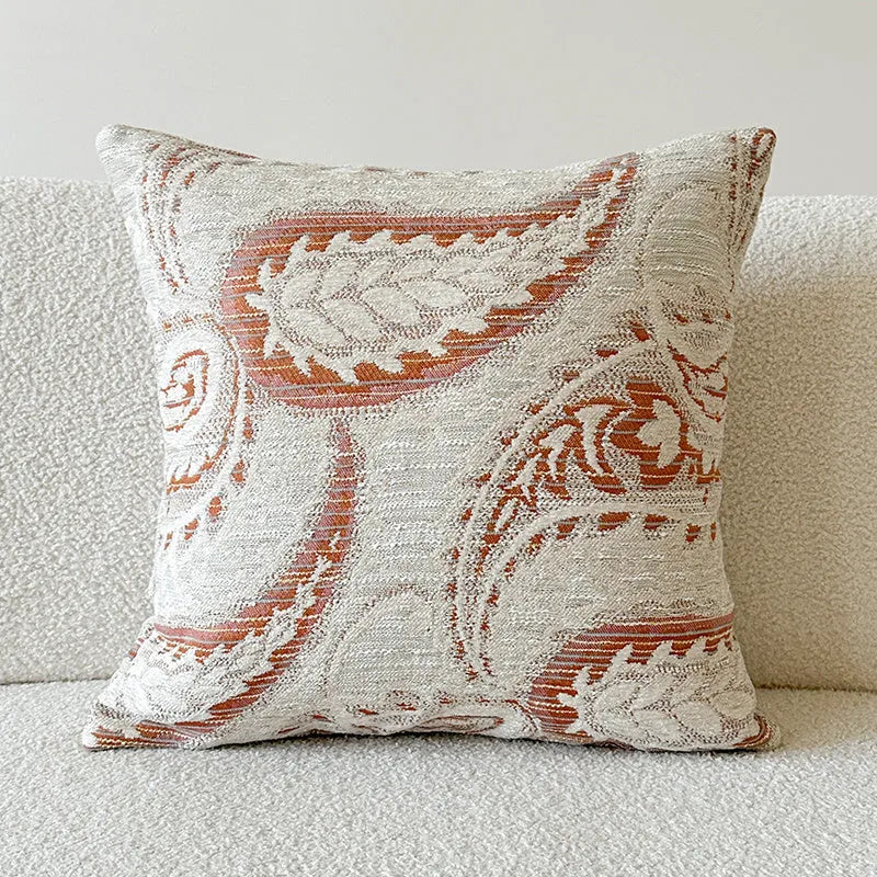American-style jacquard woven throw pillow cover with a paisley pattern in amber colours on a sofa.