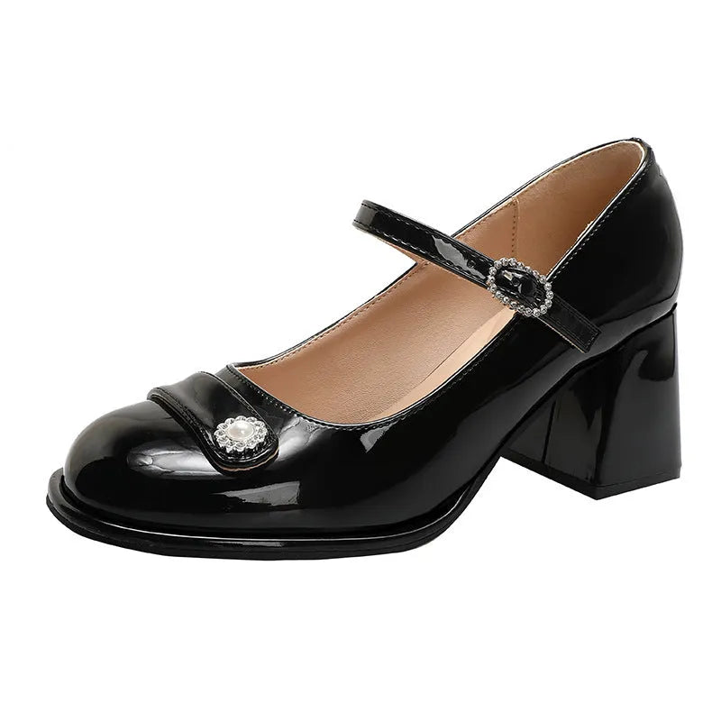 Women's black patent leather chunky heel sandals with round toe and buckle fastening.